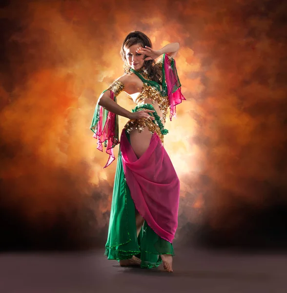 Linda mulher dançarina do ventre dançando em traje de dança do ventre tradicional sobre fundo estúdio colorido . — Fotografia de Stock