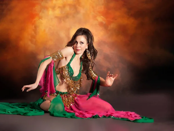 Linda mulher dançarina do ventre dançando em traje de dança do ventre tradicional sobre fundo estúdio colorido . — Fotografia de Stock