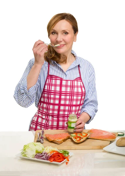 Prachtige volwassen vrouw koken in de keuken. — Stockfoto