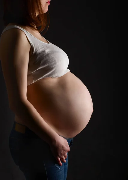 Zwangere vrouw, aanstaande moeder op zwarte achtergrond, — Stockfoto