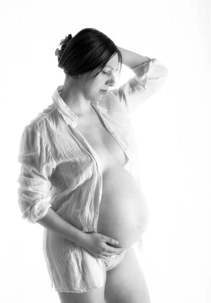 Pregnant woman, expectant mother on white background, close-up of pregnant belly, monoshrome shoot. — Stock Photo, Image