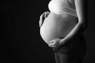 hamile kadın, siyah arka plan üzerinde anne beklentisi, monoshrome ateş.