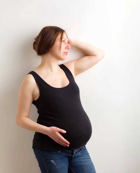 年轻孕妇，白色背景的准妈妈，怀孕腹部的特写 — 图库照片