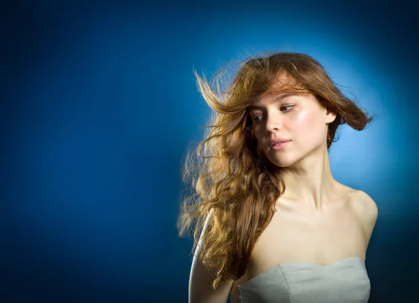 Beauty fashion portrait. Young woman on blue wall background. — Stock Photo, Image