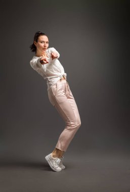 Genç ve güzel bir dansçı, renkli arka planda stüdyoda poz veriyor.