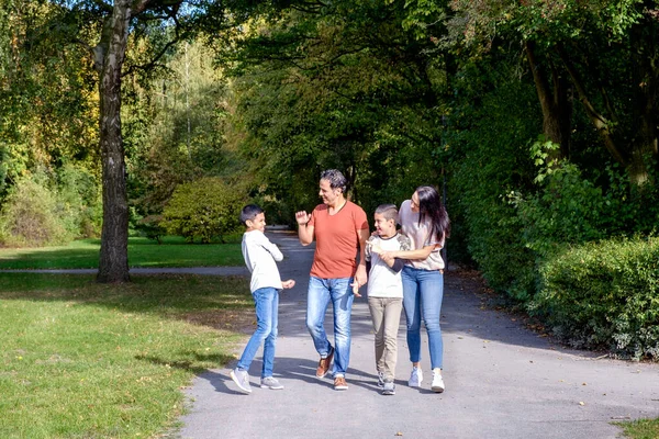 Vycházková rodina se dvěma dětmi v parku — Stock fotografie