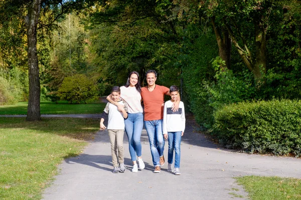 Promenadfamilj med två barn i parken — Stockfoto