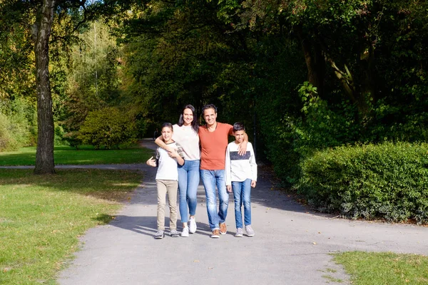 Sétáló család két gyerekkel a parkban — Stock Fotó