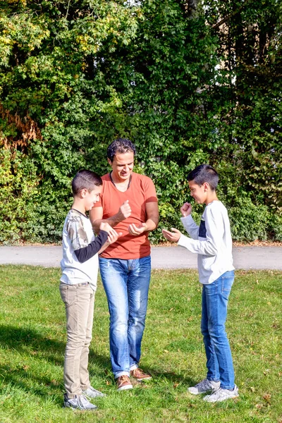 Father and teenage children in walking the park — ストック写真