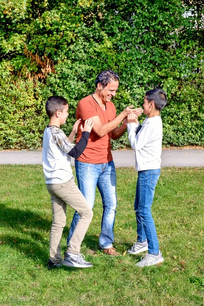 Padre e figli adolescenti a piedi nel parco — Foto Stock