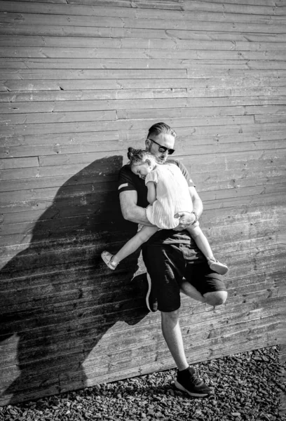 Joven padre guapo sosteniendo a su hija en sus brazos — Foto de Stock