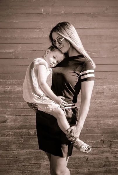 Gyönyörű anya tartja az imádnivaló három éves lányát. — Stock Fotó