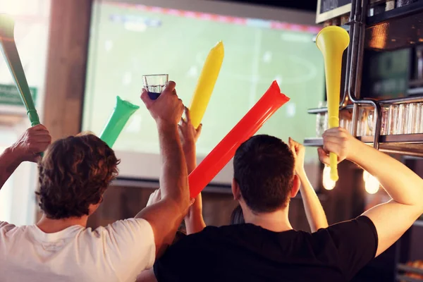 Groep vrienden kijken naar voetbal in pub — Stockfoto