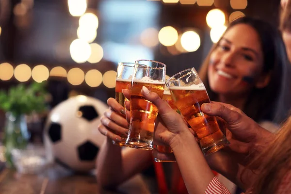 Group of friends watching soccer in pub