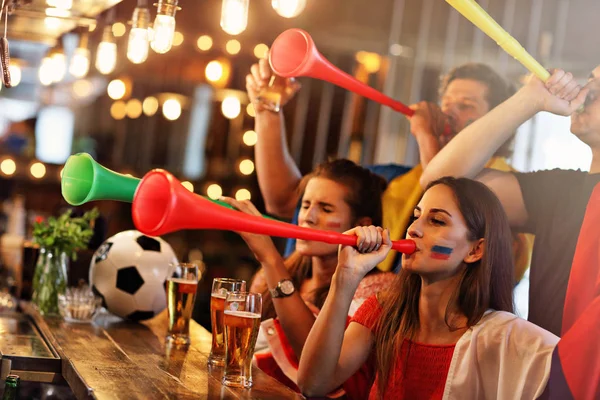 Groep vrienden kijken naar voetbal in pub — Stockfoto