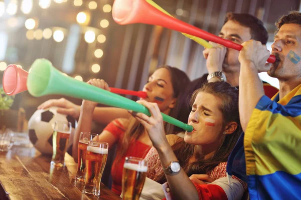 Group of friends watching soccer in pub