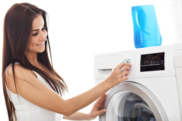 Porträt einer jungen Hausfrau mit Wäsche neben Waschmaschine — Stockfoto