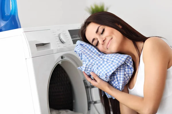 Портрет молодої домогосподарки з білизною біля пральної машинки — стокове фото
