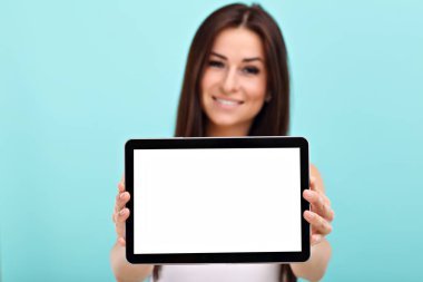 Mavi duvar arka plan karşı tablet kullanan kadın