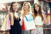 Bild zeigt glückliche Freundinnen beim Einkaufen in Einkaufszentrum