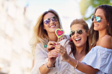 Mutlu kız arkadaşlar yaz aylarında şehirde takılmak gösteren resim