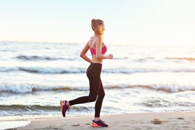 Güzel gün batımında sahilde tek başına çalışan kadın