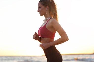 Güzel gün batımında sahilde tek başına çalışan kadın