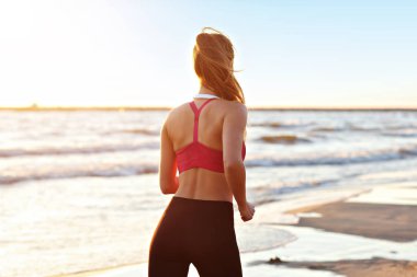 Güzel gün batımında sahilde tek başına çalışan kadın