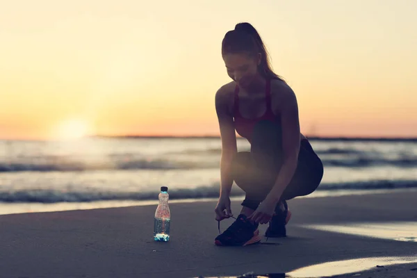 Vrouw alleen draaien op de prachtige zonsondergang op het strand — Stockfoto
