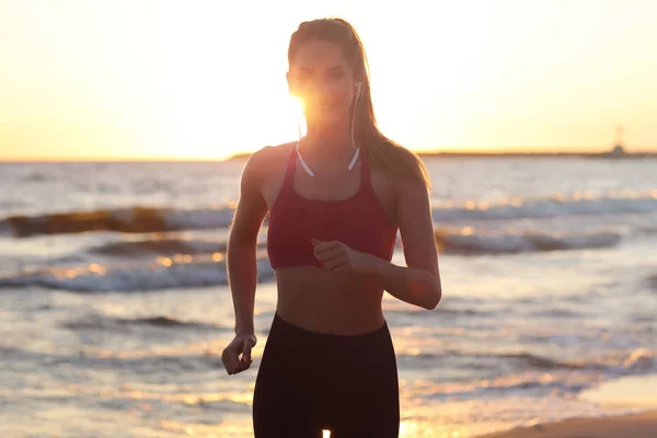 Mulher correndo sozinha ao belo crepúsculo na praia — Fotografia de Stock