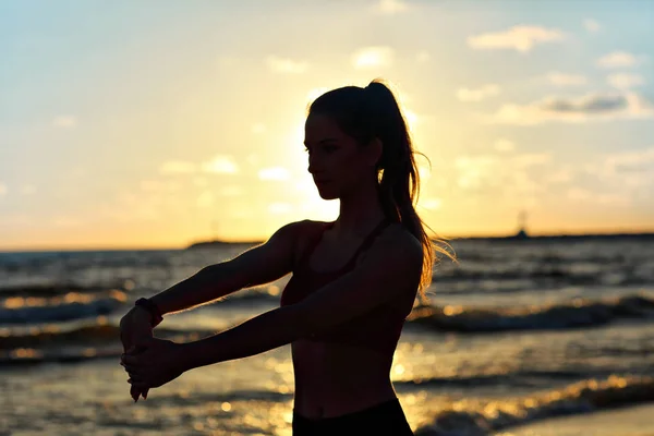 Frau läuft allein in der Dämmerung am Strand — Stockfoto