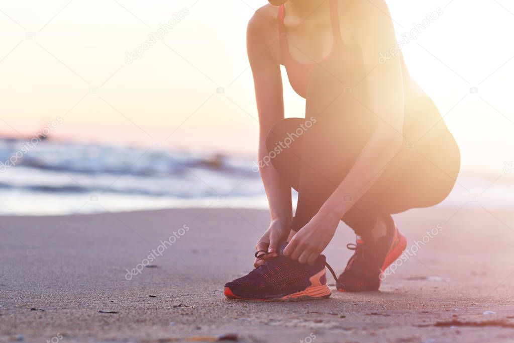 Woman running alone at beautiful dusk on the beach