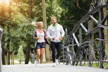 Genç çift parkta koşuyor.