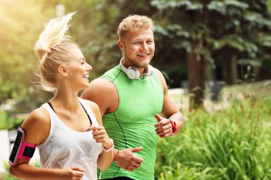 Genç çift parkta koşuyor.
