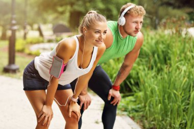 Genç çift parkta koşuyor.