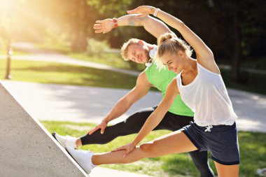 Genç çift parkta koşuyor.