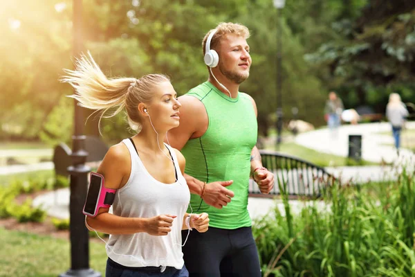 Genç çift parkta koşuyor.