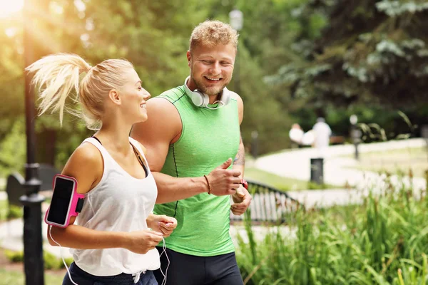 Genç çift parkta koşuyor.