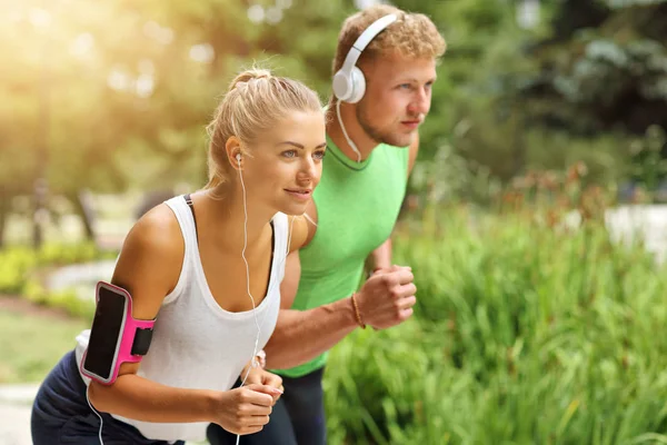 Genç çift parkta koşuyor.