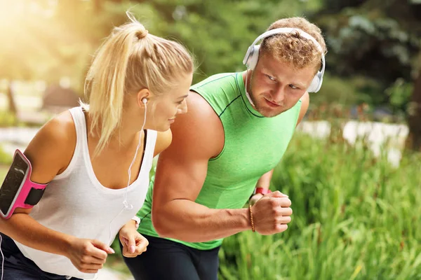 Genç çift parkta koşuyor.