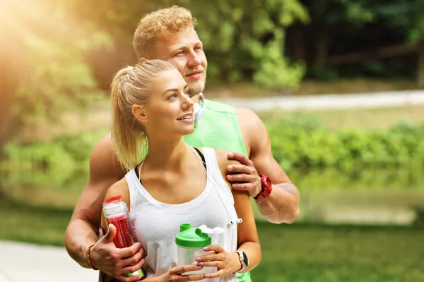 Genç çift parkta koşuyor.