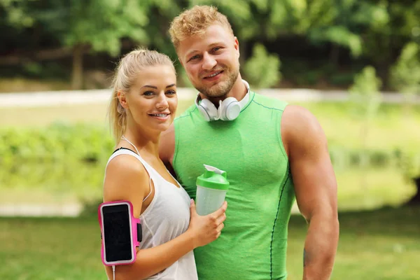 Genç çift parkta koşuyor.