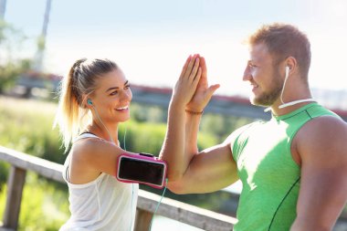 Genç çift parkta koşuyor.