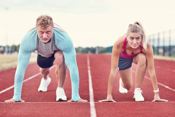 Homem e mulher competindo na pista ao ar livre — Fotografia de Stock