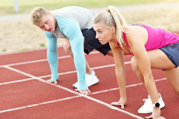 Homem e mulher competindo na pista ao ar livre — Fotografia de Stock