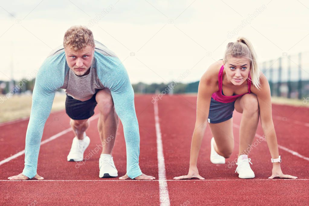 Man and woman racing on outdoor track