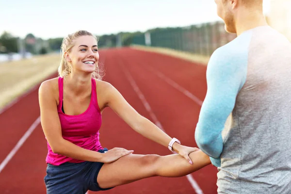 Hombre y mujer corriendo en pista al aire libre — Foto de Stock