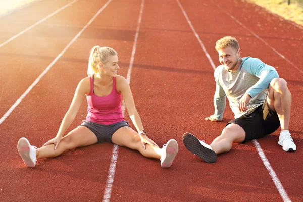 Man and woman racing on outdoor track — Stock Photo, Image