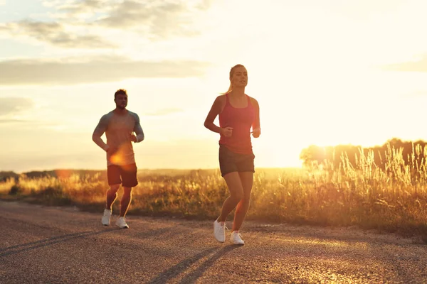 Junges Paar joggt nach Sonnenuntergang in der U-Bahn — Stockfoto