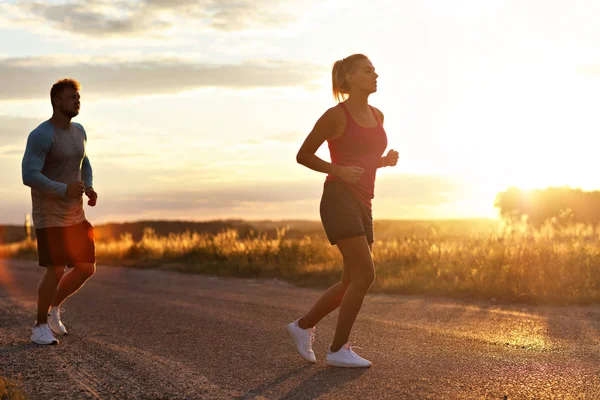 Junges Paar joggt nach Sonnenuntergang in der U-Bahn — Stockfoto